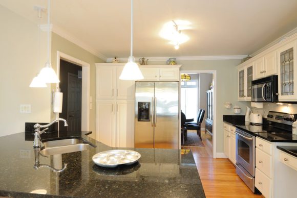 Remodeled kitchen in Oaklawn, IL, with granite counters, white cabinets, and stainless steel appliances.